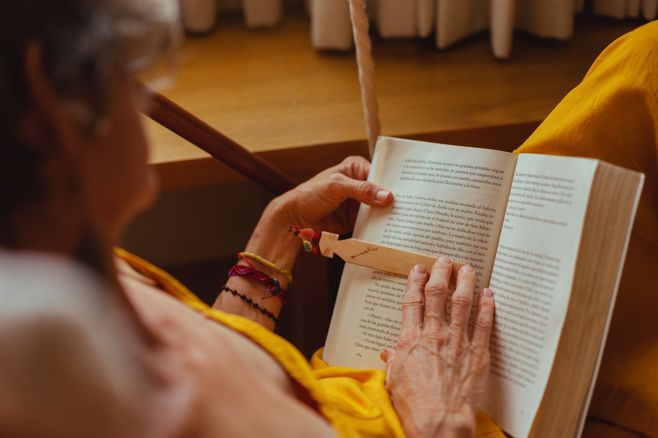 Senior adult reading a book indoors, focusing on leisure and relaxation.